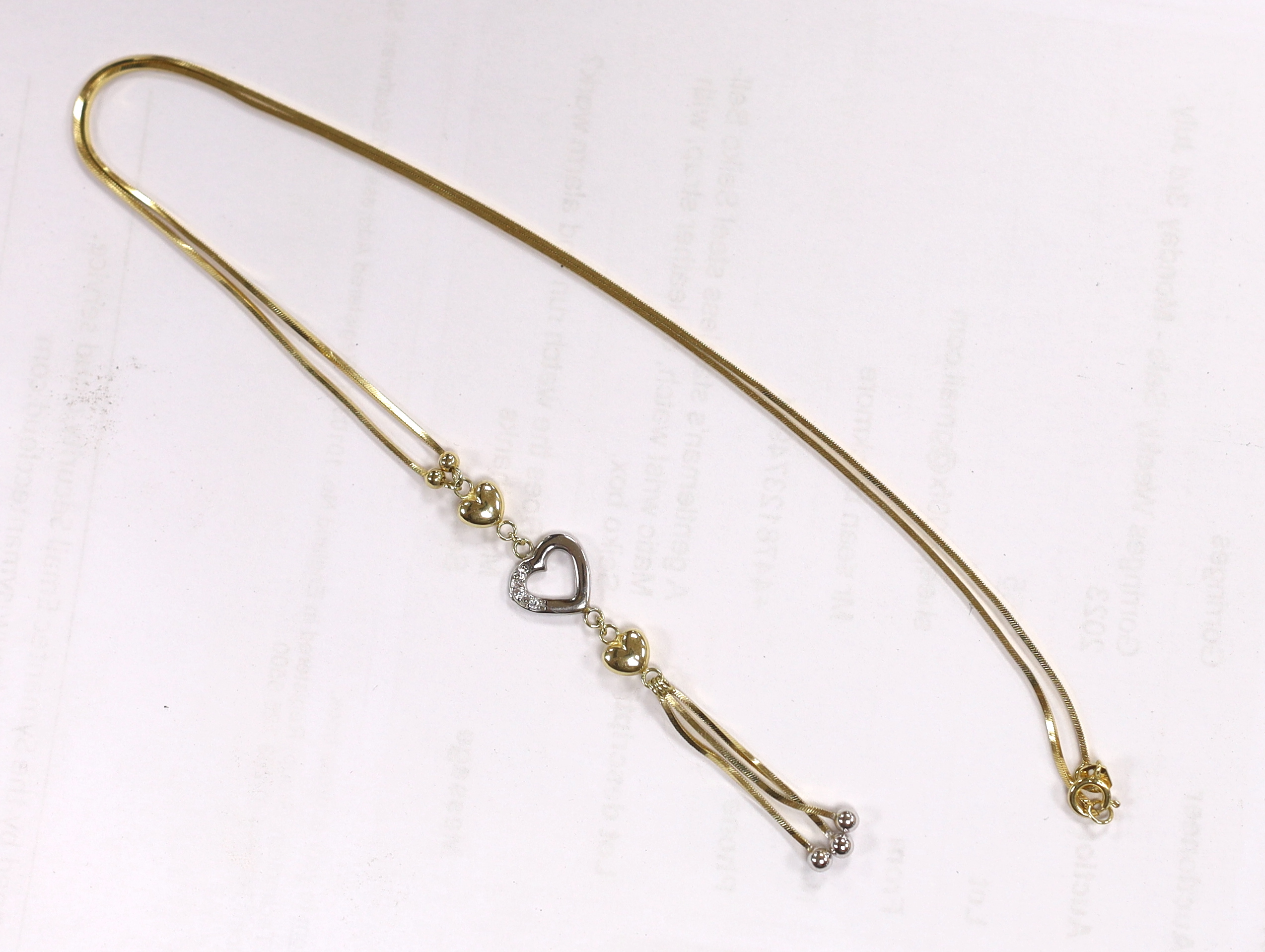 A modern two colour 14k and three white stone set heart drop tassel necklace, 56cm, gross weight, 4.7 grams.